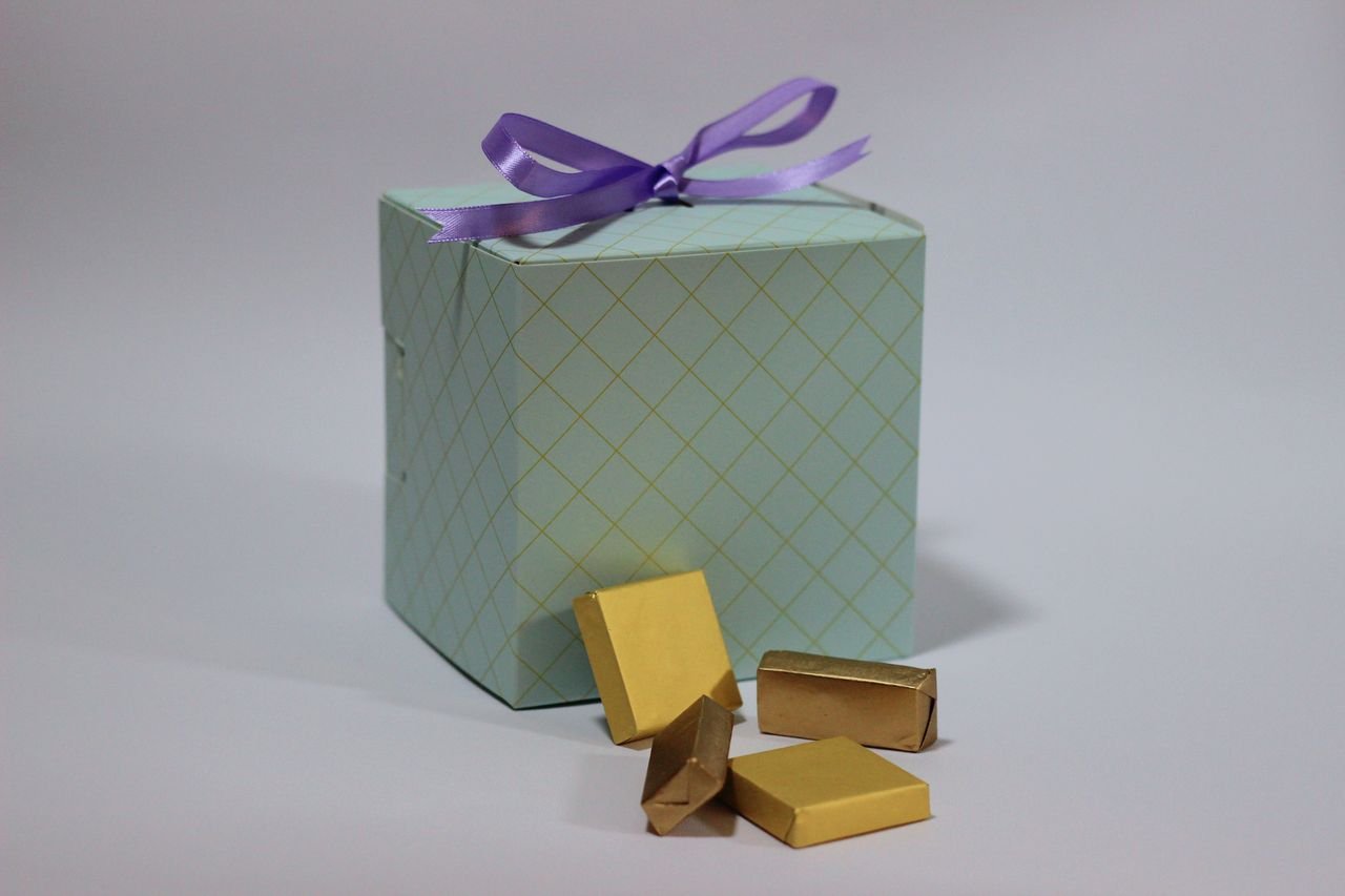 services-03 A pastel gift box with a purple ribbon and gold-wrapped chocolates perfect for celebrations.
