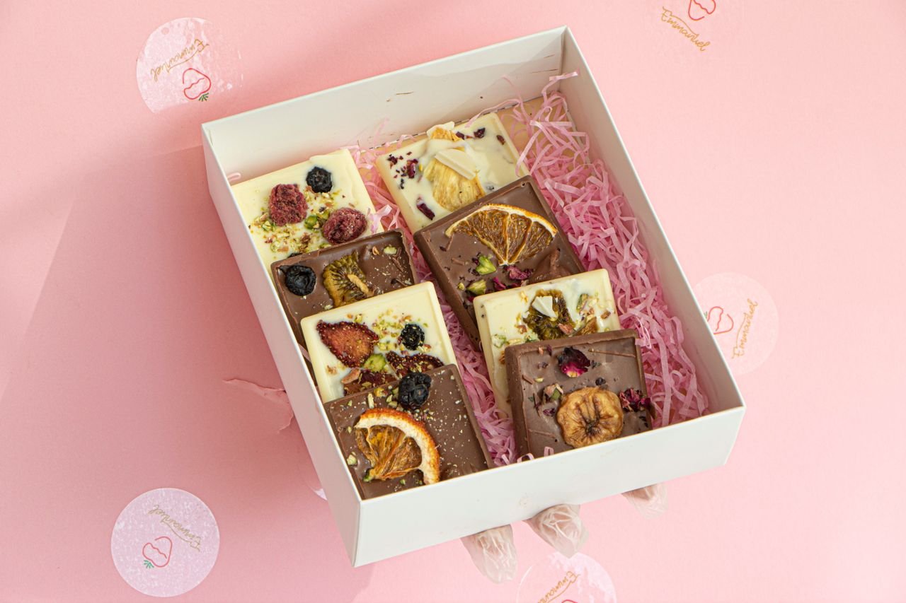 Elegant box of artisanal chocolate bars topped with dried fruits, perfect for a unique gift.